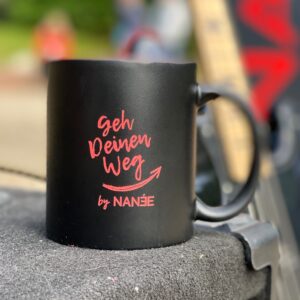 Becher "Geh Deinen Weg!" von NANÉE, Schwarzer Keramikbecher, Innen rot, mit hochwertiger roter Lasergravur "Geh Deinen Weg" by NANÉE